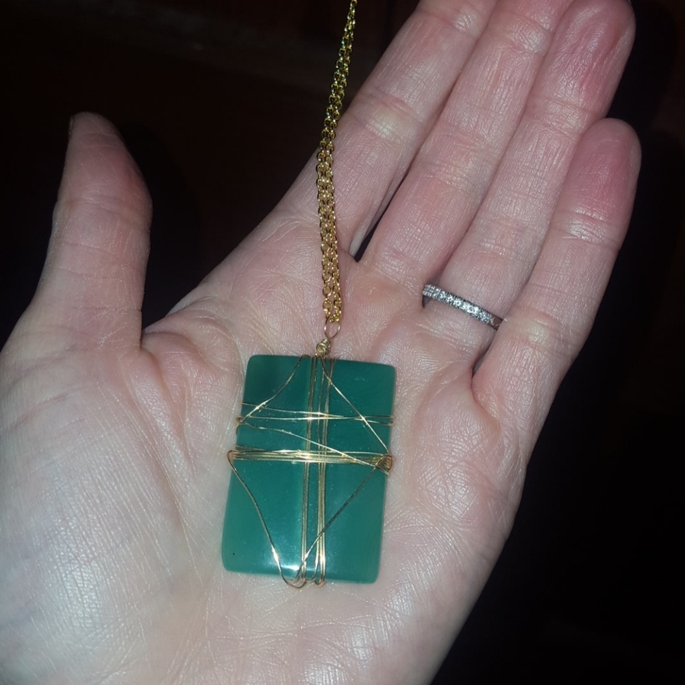 Wire wrapped green stone necklace on gold chain.